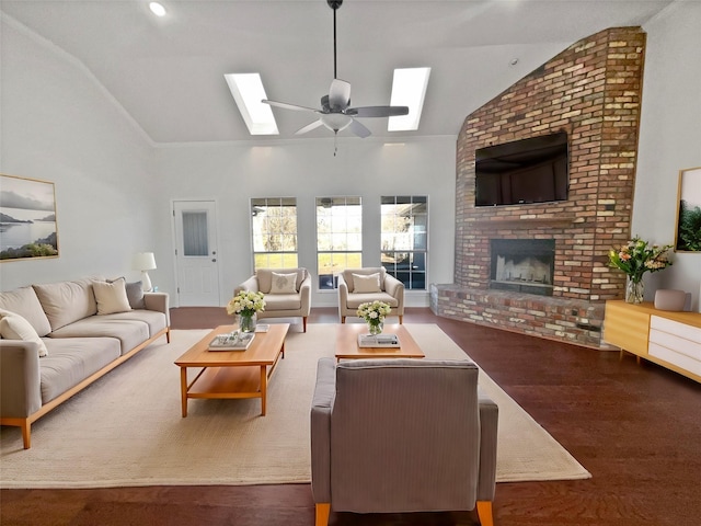 living room with dark wood-type flooring, a skylight, high vaulted ceiling, ceiling fan, and a fireplace