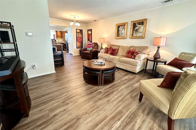 living room with hardwood / wood-style floors, ornamental molding, and a chandelier