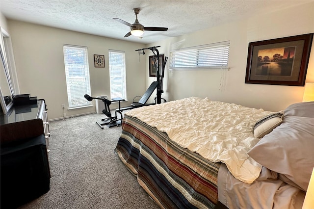 carpeted bedroom featuring ceiling fan and a textured ceiling