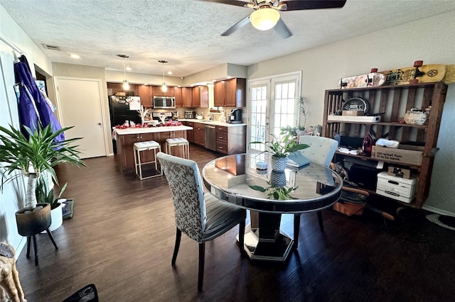 dining space with dark wood-type flooring, ceiling fan, a textured ceiling, and french doors