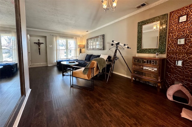 living room featuring crown molding, dark hardwood / wood-style floors, a chandelier, and a textured ceiling