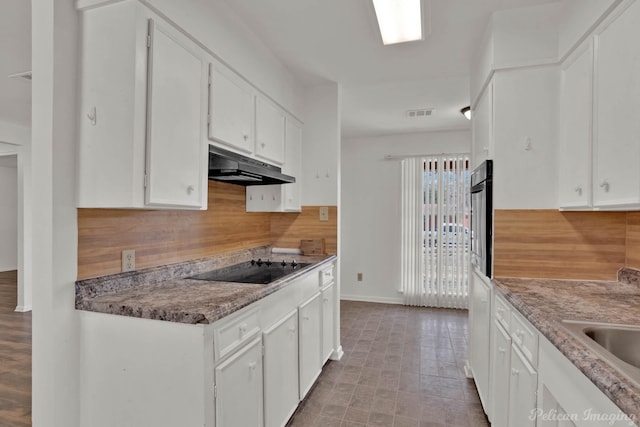 kitchen with white cabinetry, light stone counters, tasteful backsplash, and black appliances