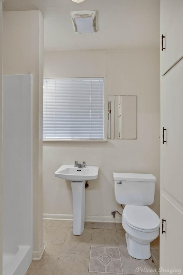 bathroom featuring toilet and tile patterned flooring