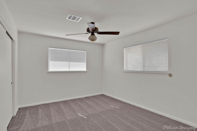 empty room with ceiling fan and carpet floors