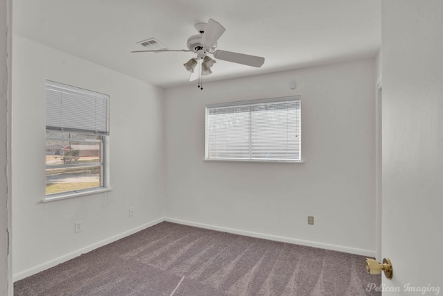 carpeted spare room featuring a healthy amount of sunlight and ceiling fan