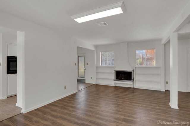 unfurnished living room with dark hardwood / wood-style flooring and a fireplace