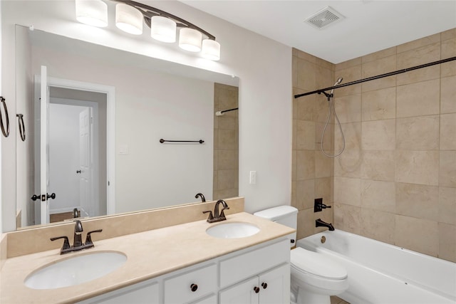 full bathroom with vanity, tiled shower / bath combo, and toilet