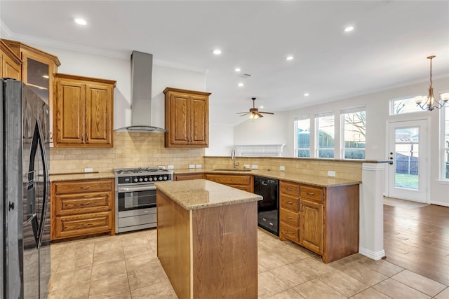 kitchen featuring pendant lighting, wall chimney range hood, sink, black appliances, and kitchen peninsula