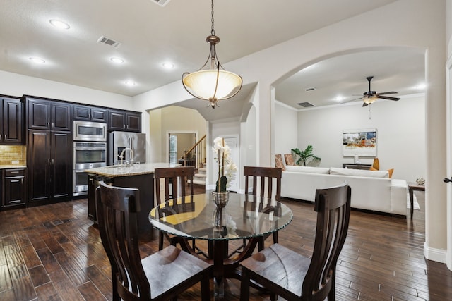 dining area featuring crown molding, dark hardwood / wood-style floors, and ceiling fan