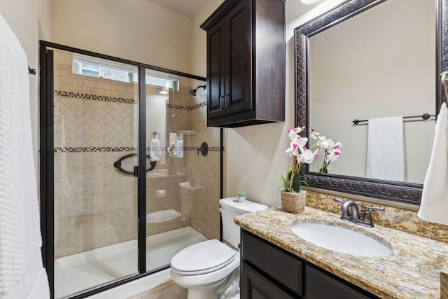 bathroom featuring an enclosed shower, vanity, and toilet