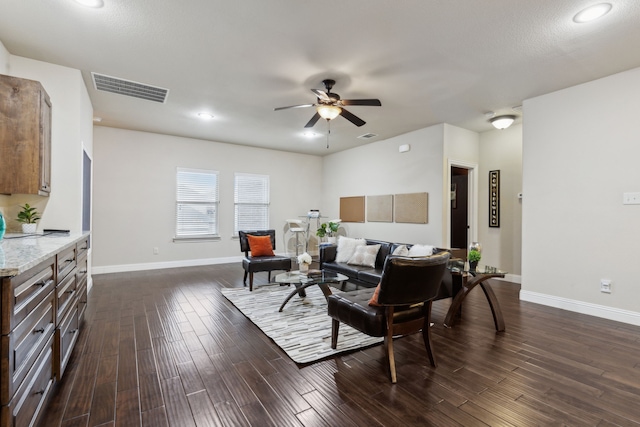 living room featuring ceiling fan and dark hardwood / wood-style floors