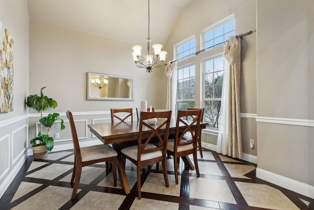 dining space featuring a chandelier and high vaulted ceiling