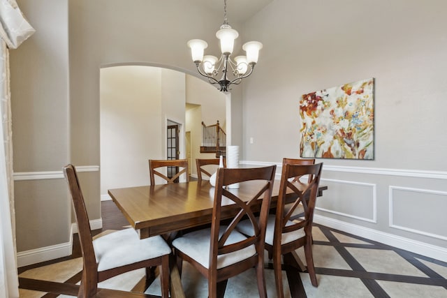 dining space featuring high vaulted ceiling and a notable chandelier