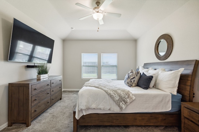 bedroom with lofted ceiling, light colored carpet, a raised ceiling, and ceiling fan