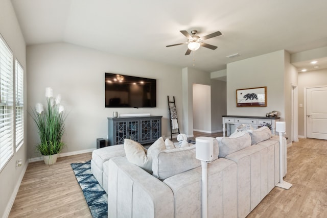 living room with lofted ceiling, ceiling fan, and light wood-type flooring