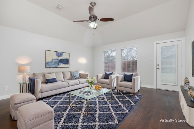 living area featuring lofted ceiling, visible vents, dark wood-type flooring, a ceiling fan, and baseboards