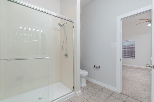 full bath with toilet, a stall shower, ceiling fan, baseboards, and tile patterned floors