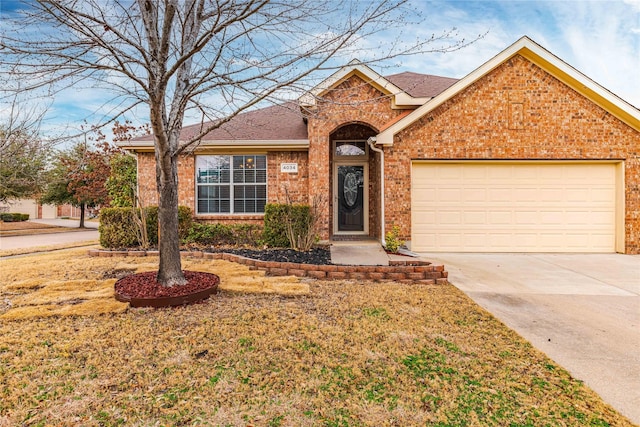 ranch-style house with concrete driveway, brick siding, an attached garage, and roof with shingles