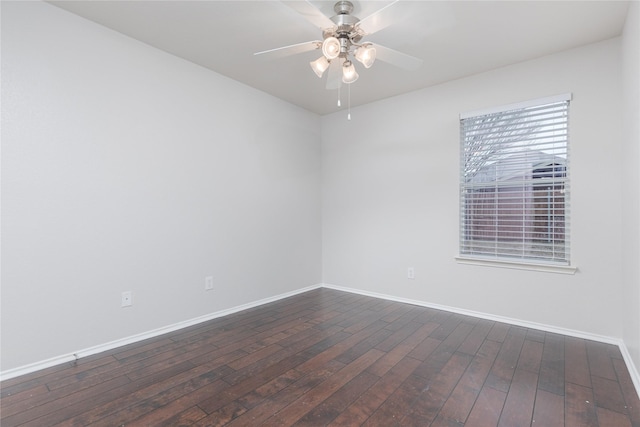 empty room with dark wood finished floors, baseboards, and ceiling fan