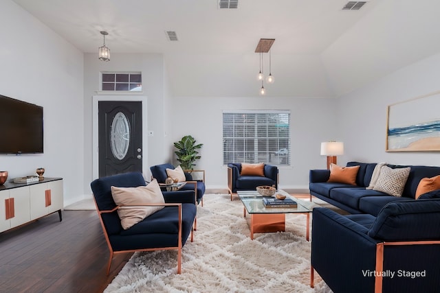 living room featuring lofted ceiling, hardwood / wood-style floors, and visible vents