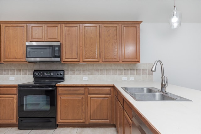 kitchen with a sink, stainless steel microwave, light countertops, and black range with electric stovetop