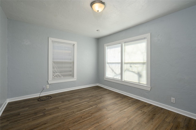 spare room with dark hardwood / wood-style flooring and a textured ceiling