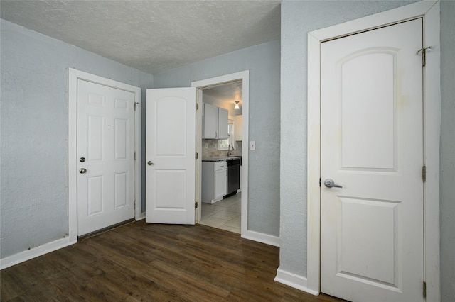 interior space featuring sink, dark wood-type flooring, and a textured ceiling