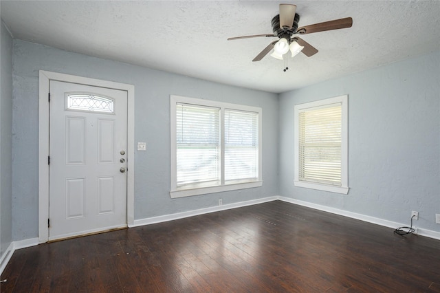 entryway featuring ceiling fan, dark hardwood / wood-style floors, and a textured ceiling