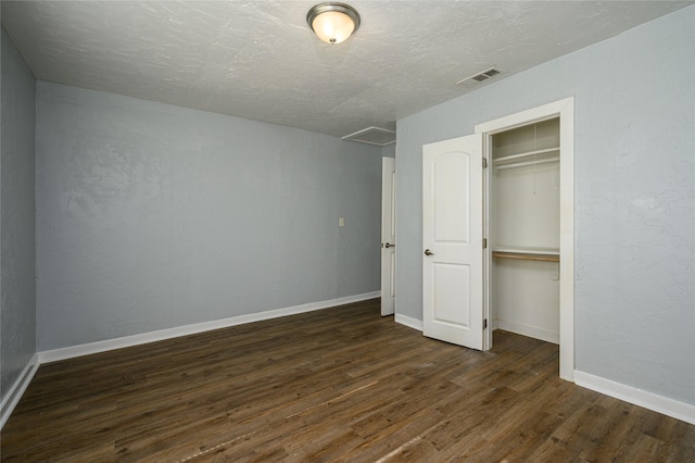 unfurnished bedroom with dark hardwood / wood-style floors, a closet, and a textured ceiling