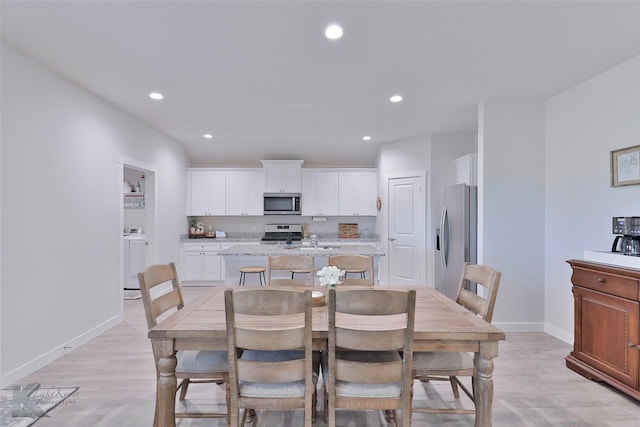 dining room with sink and light hardwood / wood-style flooring