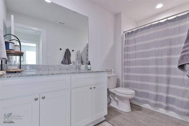 bathroom with hardwood / wood-style flooring, vanity, and toilet