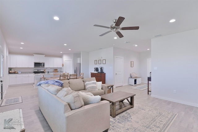 living room featuring ceiling fan and light wood-type flooring