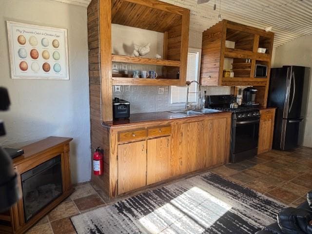 kitchen with black refrigerator, sink, and range with gas stovetop