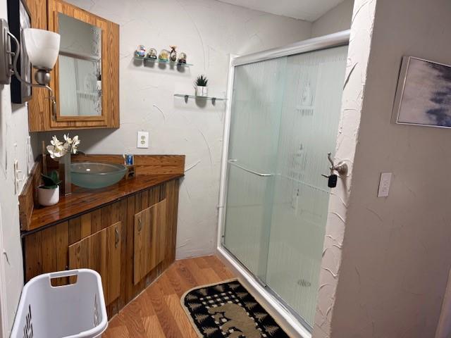 bathroom featuring a shower with door, wood-type flooring, and vanity