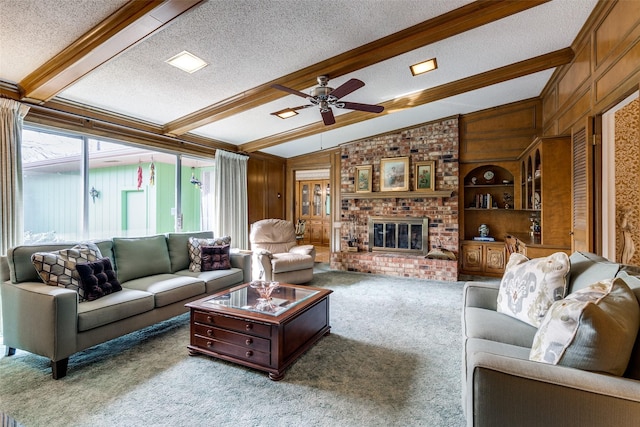 living area with lofted ceiling with beams, wood walls, a brick fireplace, and a textured ceiling