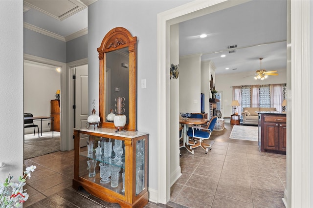 corridor featuring ornamental molding and light tile patterned floors