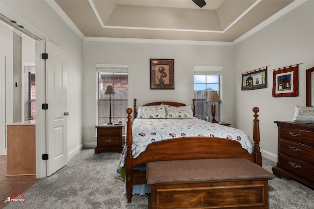 bedroom with ceiling fan, ornamental molding, a raised ceiling, and carpet floors