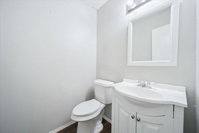 bathroom with vanity, toilet, and hardwood / wood-style floors