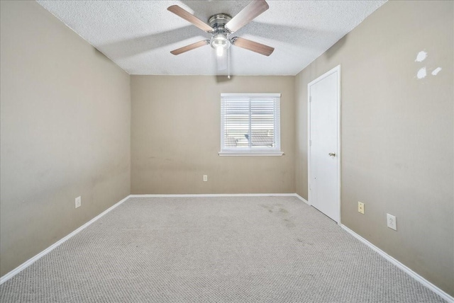 unfurnished room with ceiling fan, light colored carpet, and a textured ceiling