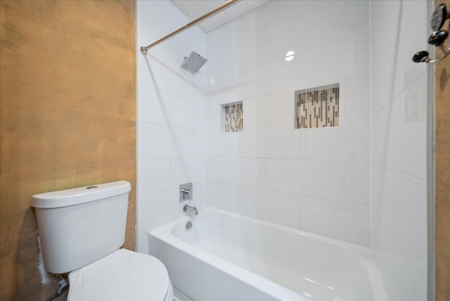 bathroom featuring tiled shower / bath and toilet