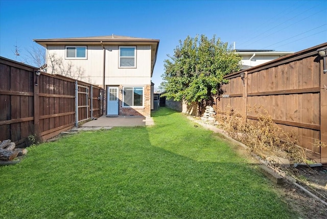 rear view of house with a patio and a lawn