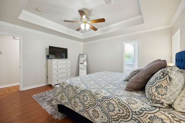 bedroom featuring ceiling fan, ornamental molding, dark hardwood / wood-style floors, and a raised ceiling