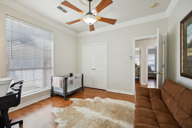 home office featuring crown molding, ceiling fan, and light hardwood / wood-style flooring