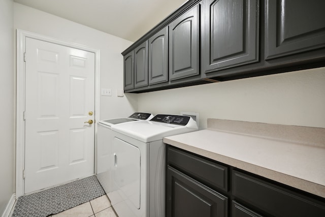 laundry area featuring cabinets, washing machine and clothes dryer, and light tile patterned flooring