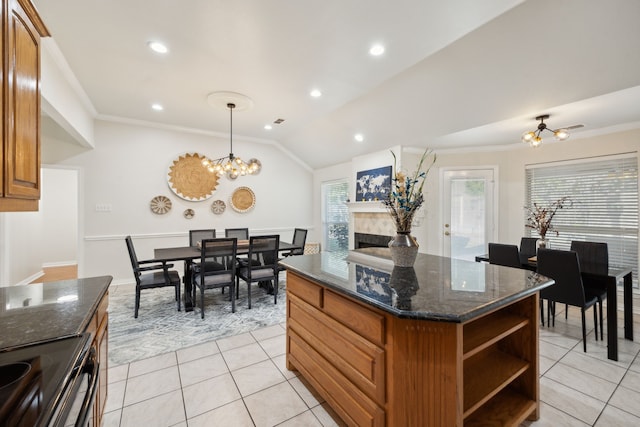 kitchen with hanging light fixtures, crown molding, a center island, and light tile patterned floors