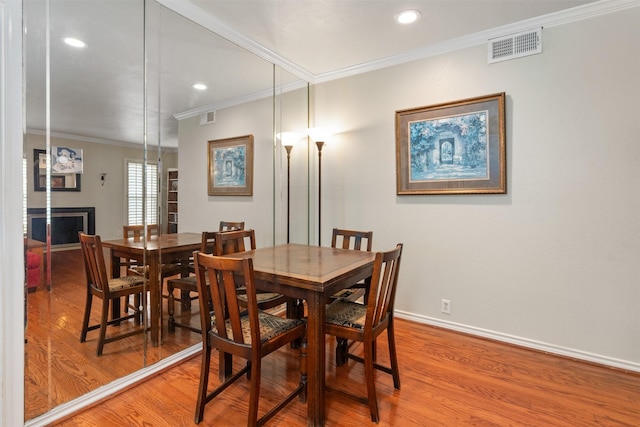 dining room with crown molding and hardwood / wood-style floors