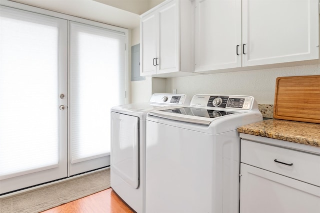 washroom featuring light hardwood / wood-style floors, cabinets, and washing machine and clothes dryer