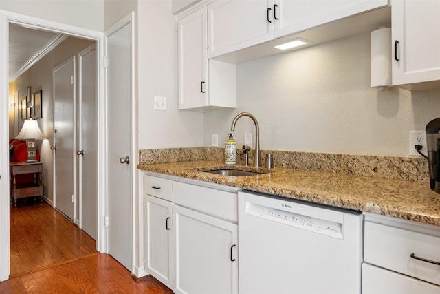 kitchen featuring white cabinetry, sink, hardwood / wood-style flooring, light stone counters, and white dishwasher