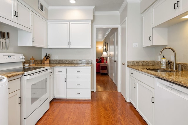 kitchen with sink, white appliances, light hardwood / wood-style flooring, ornamental molding, and white cabinets