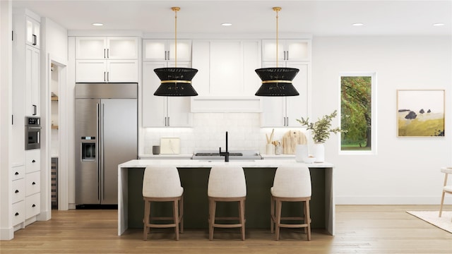 kitchen featuring white cabinetry, decorative backsplash, stainless steel appliances, and an island with sink